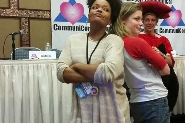 Fans posing together in front of a CommuniCon backdrop